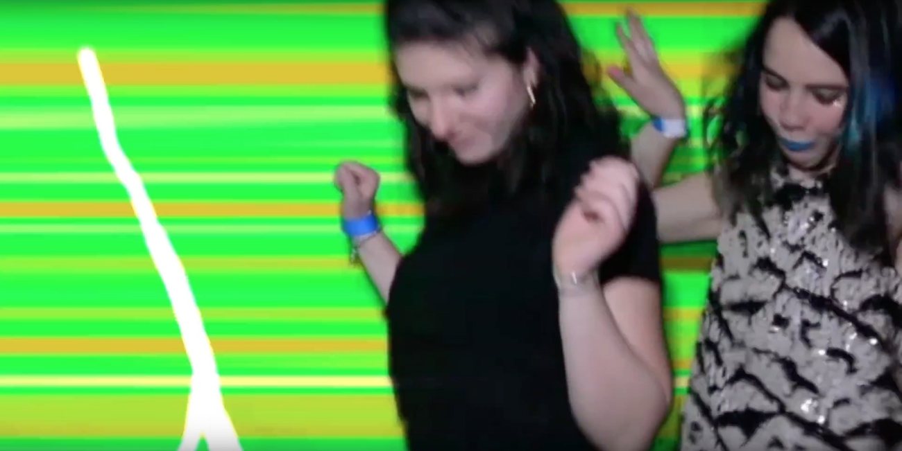 People dancing in front of green striped projections