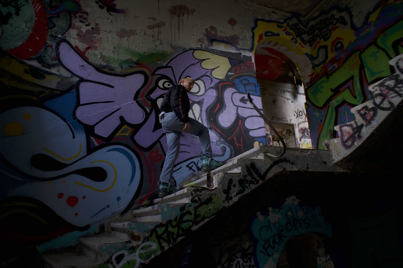 Inner Rave — model on a graffiti staircase with a purple mural