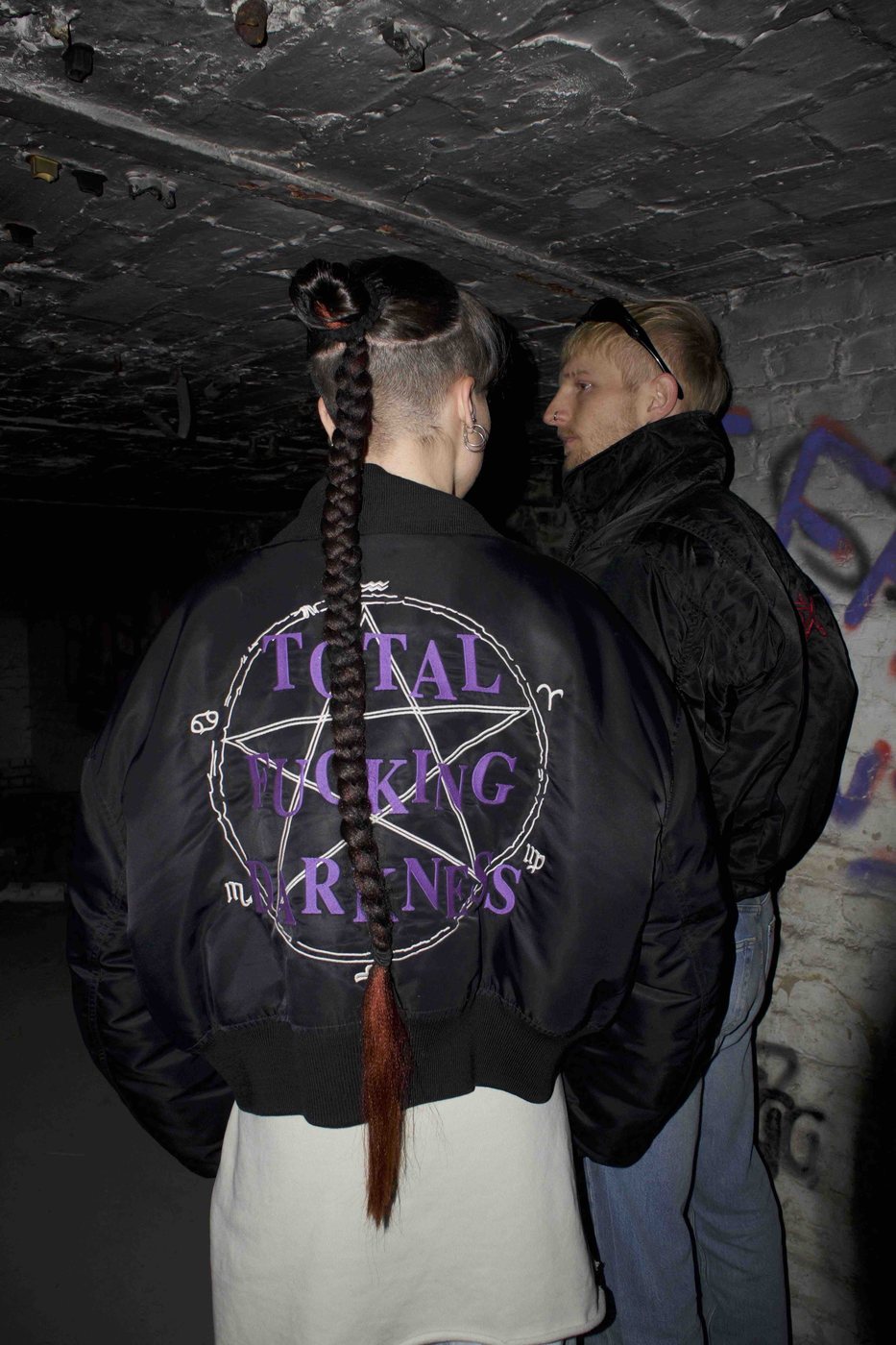 Inner Rave — back view of an embroidered bomber jacket in a dark corridor