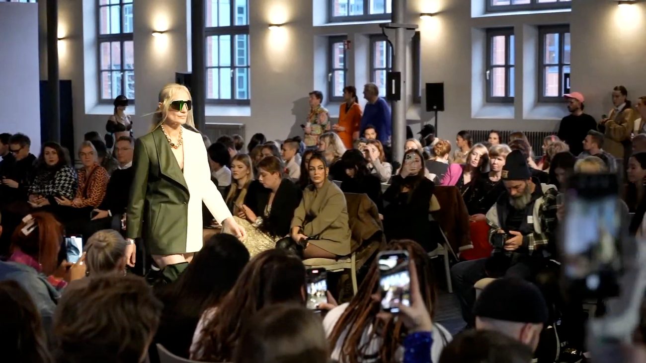 WE.4 runway — three models under neon-lit stage