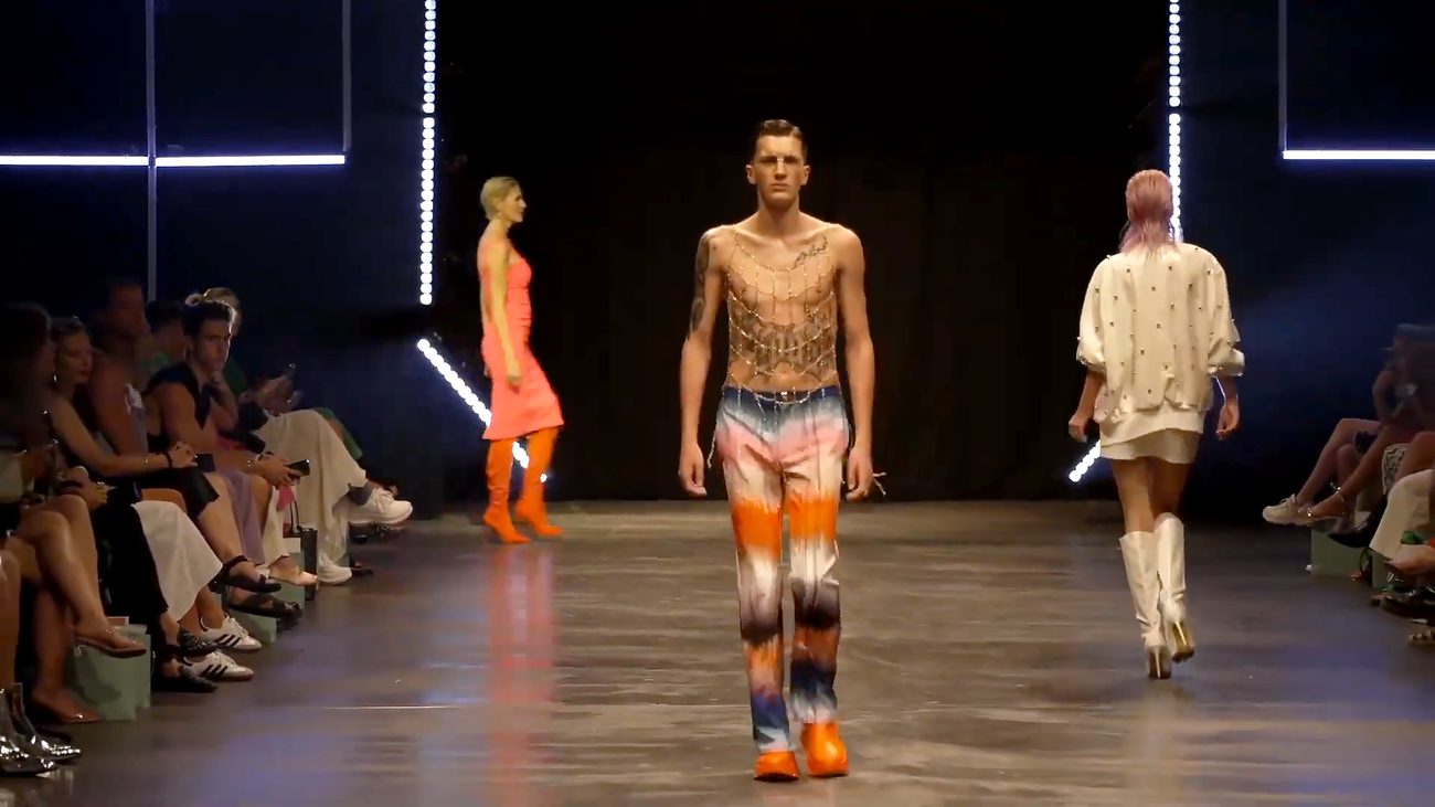 WE.4 runway — model in tie-dye trousers and chain top