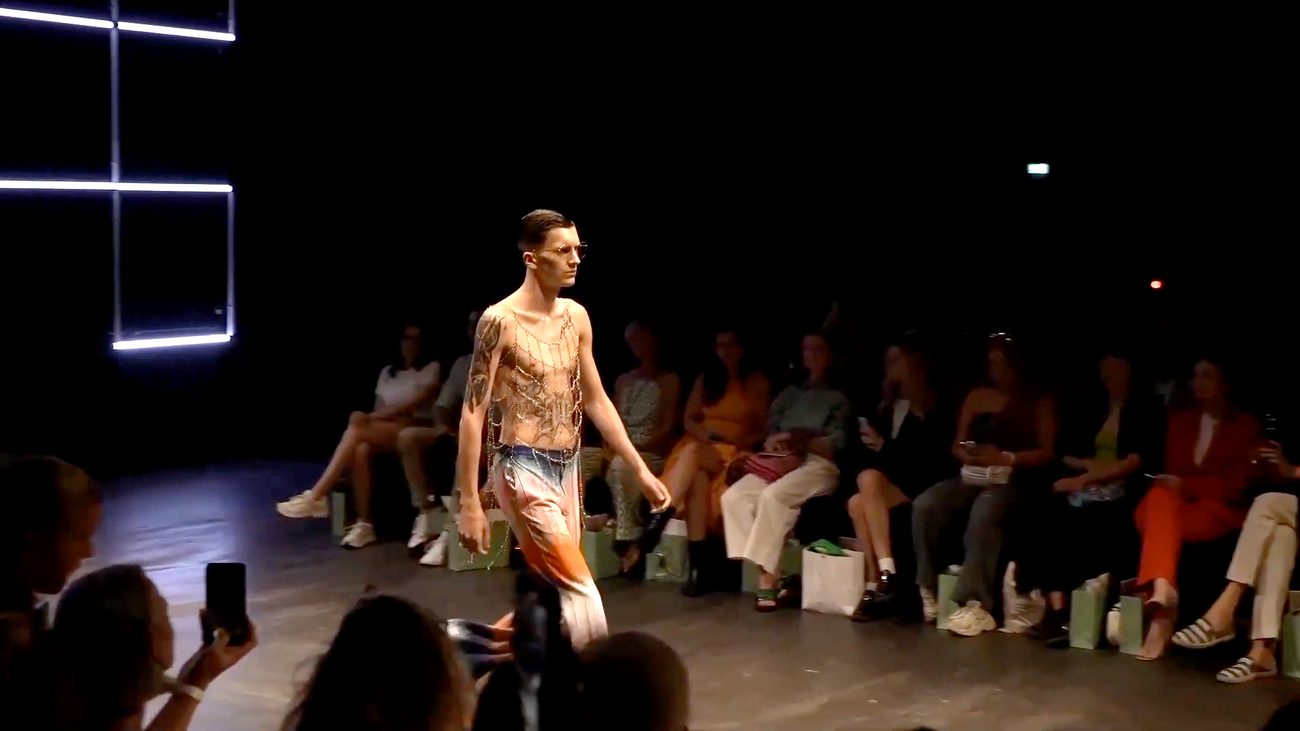 WE.4 runway — model in orange under octagon lights