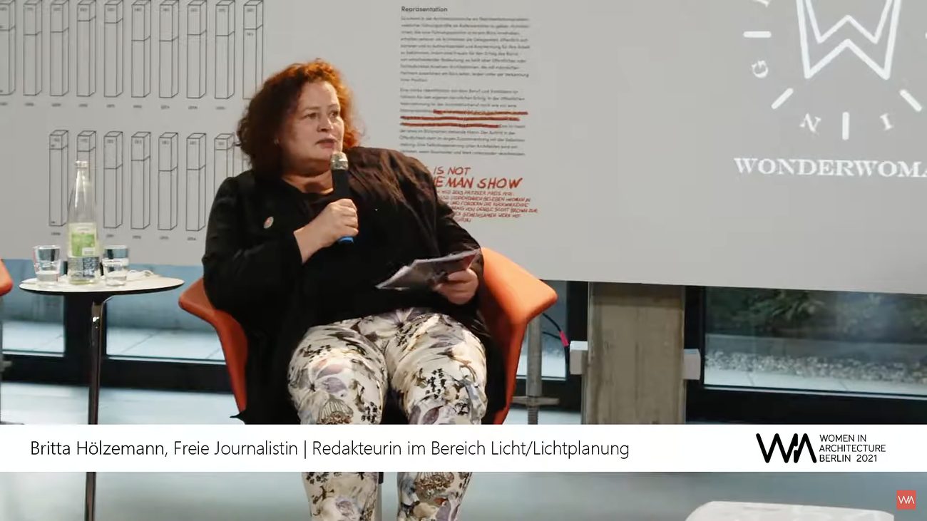 WIA Berlin — speaker at the microphone in front of exhibition panels